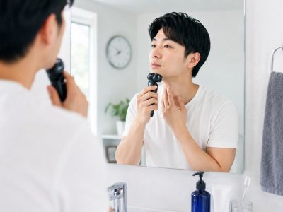 ひげ剃りを行う男性