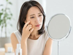 目元や口元のしわが気になり鏡を見る女性