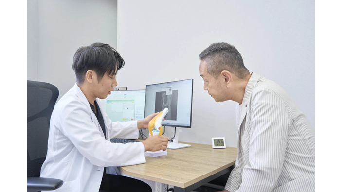 膝の模型を使って治療方針を説明する、SAクリニック院長の宮路啓太先生